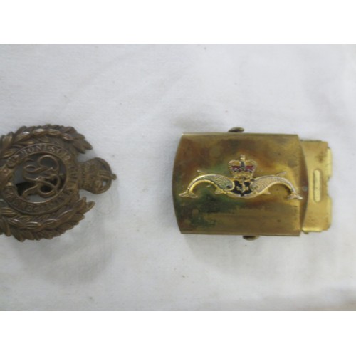 215 - An RN Submarines belt buckle, several pre-WW2 button slides, a Royal Engineers cap badge, a white me... 