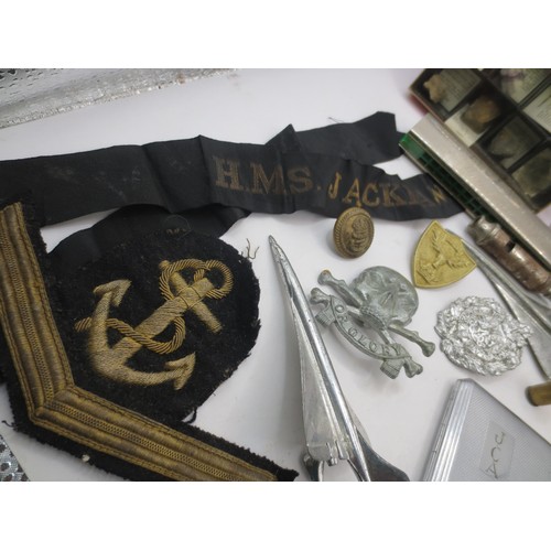 208 - An assortment of militaria and other items including RN chevron in bullion braid, a cap tally for HM... 