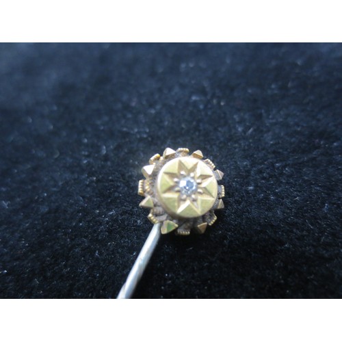 215 - A gentleman's tie pin, base metal shaft, round gold stud with central clear stone (does not test as ... 