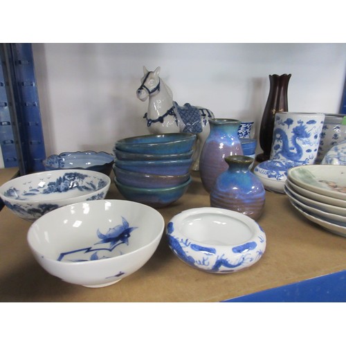 32 - A shelf of Chinese, Japanese and far Eastern decorative pottery and porcelain, mainly blue and white... 