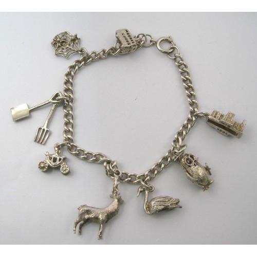 38 - A white metal charm bracelet, clasp stamped sterling, with eight white metal charms - York Minster, ... 