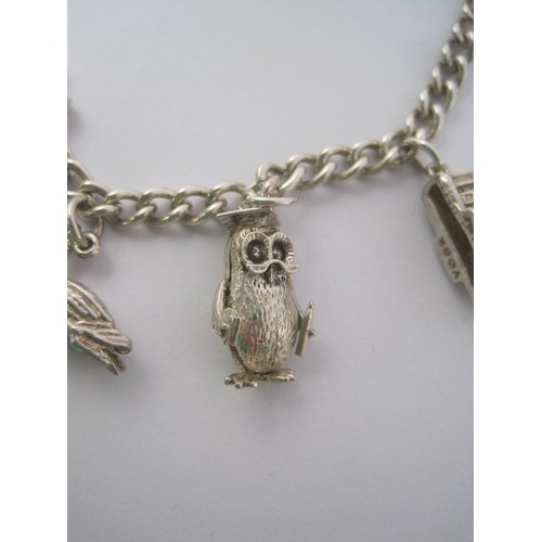38 - A white metal charm bracelet, clasp stamped sterling, with eight white metal charms - York Minster, ... 