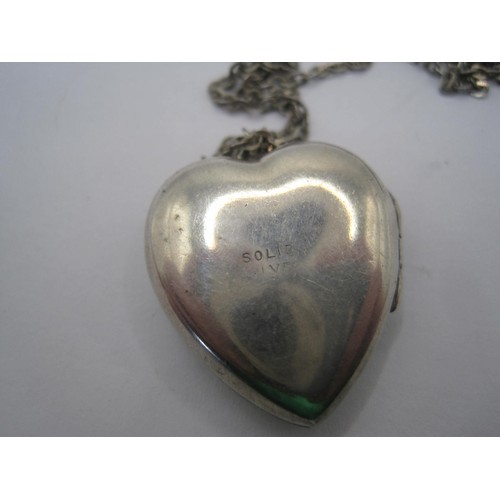 40 - A heart-shaped locket with foliate engraving to one side, stamped solid silver, with trace chain sta... 