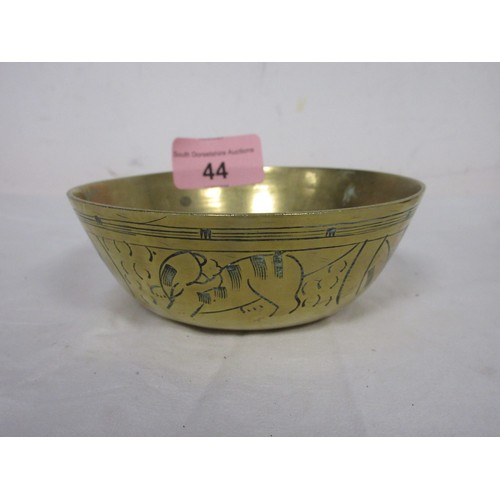 44 - Two heavy brass manillas, an engraved brass cigarette box marked Kinco, and a small brass bowl (diam... 