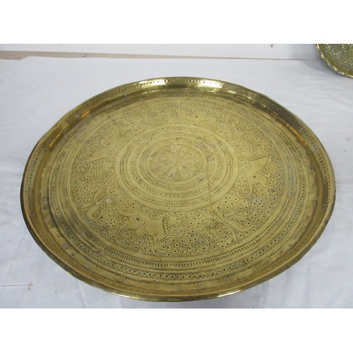 48 - An eastern circular brass tray engraved with lions and figures (diameter 43cm), a brass tray embosse... 