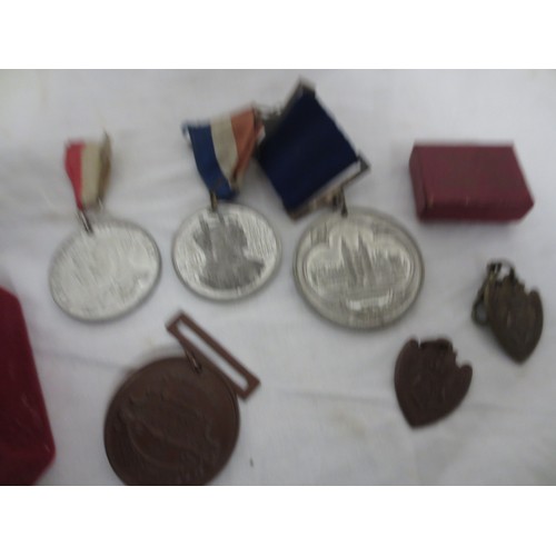 7 - A velvet box with white metal top containing an assortment of medals and fobs, including a sterling ... 