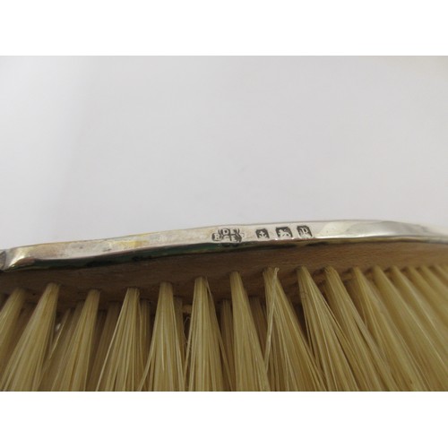 13 - An inlaid silver and tortoiseshell four-piece dressing table set comprising a clothes brush, two han... 