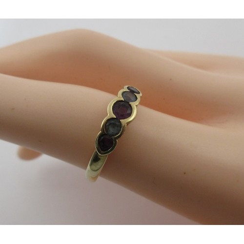 17 - A 9 carat imported gold ring set with a row of five stones (three amethysts spaced with two pale blu... 