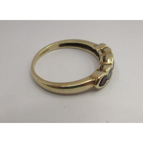 17 - A 9 carat imported gold ring set with a row of five stones (three amethysts spaced with two pale blu... 