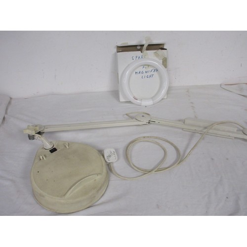 26 - A desk mounted lit and magnifying anglepoise lamp with spare ring bulb