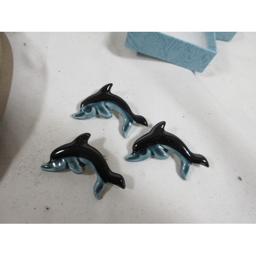 134 - Three Poole Pottery ceramic Dolphin brooches along with a Barbera Linley Adams plaque and two tradit... 