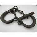 An antique set of manacles or handcuffs, rusted but essentially intact