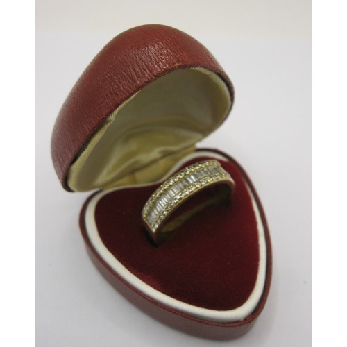 1 - An 18 carat gold ring with a distinctive setting of twenty baguette cut diamonds between two rows of... 
