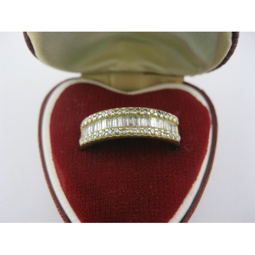 1 - An 18 carat gold ring with a distinctive setting of twenty baguette cut diamonds between two rows of... 
