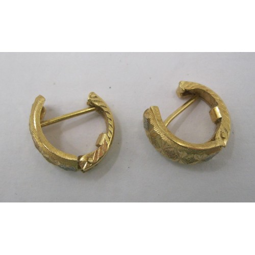 13 - A pair of 18 carat foreign gold earrings, of hinged open loop form, two-tone, with geometric facetin... 