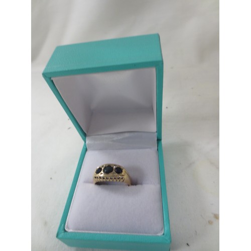 59 - A 9 carat gold ring set with red stones, likely garnets, approx weight 2.2g, ring size K