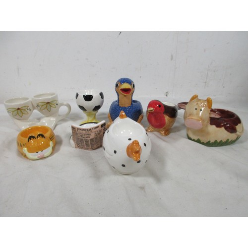 21 - A lovely selectio of Egg Cups to Include Garfield, Possably Rod Hulls Emu, Sitting cow,Robin , Finan... 