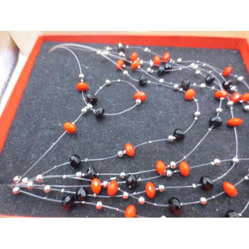 25 - A white plastic box with assorted costume jewellery,  and three boxed items of costume jewellery