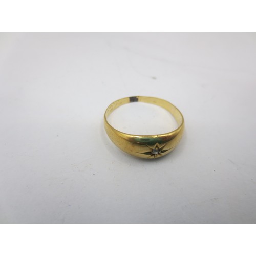 5 - A gold ring set with a small diamond in a flush star-engraved setting. Ring size R,  gross approx. 2... 