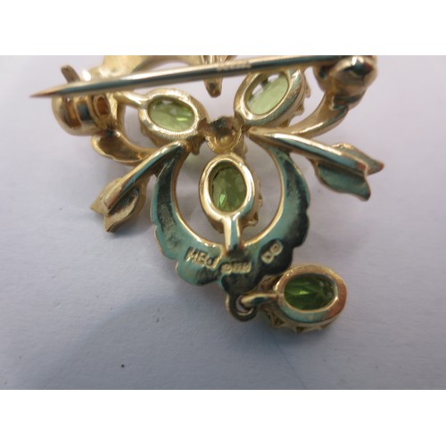 11 - A 9 carat gold trefoil pendant brooch set with green stones (probably citrine) and seed pearls, with... 