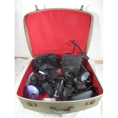 134 - A vintage suitcase full of vintage photographic equipment including camera bodies, lenses etc