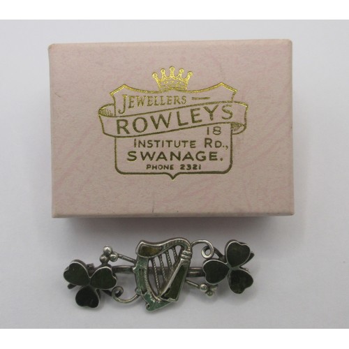157 - A sterling silver brooch with an Irish theme with a central harp of Erin flanked by shamrocks, the w... 