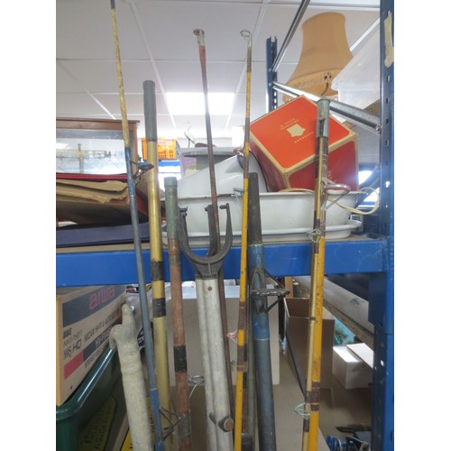 175 - A large bundle of vintage fishing rods, rod rests etc