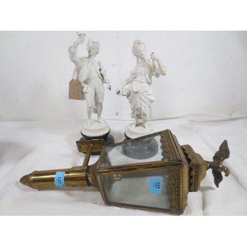 127 - A wall-mounting coaching style brass lamp, electric fitting, scallop shell border and surmounted by ... 