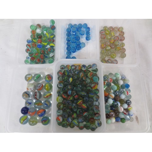 64 - A collection of glass marbles, including cats eye, swirled, blue, etc,  the contents of six plastic ... 