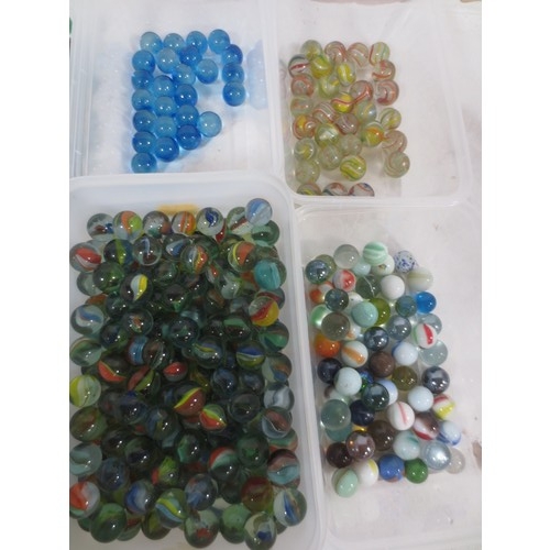 64 - A collection of glass marbles, including cats eye, swirled, blue, etc,  the contents of six plastic ... 