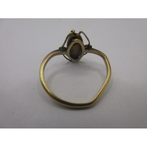 83 - An Edwardian yellow metal ring set with an oval striated green stone or bead (9mm x 4mm).  Gross app... 