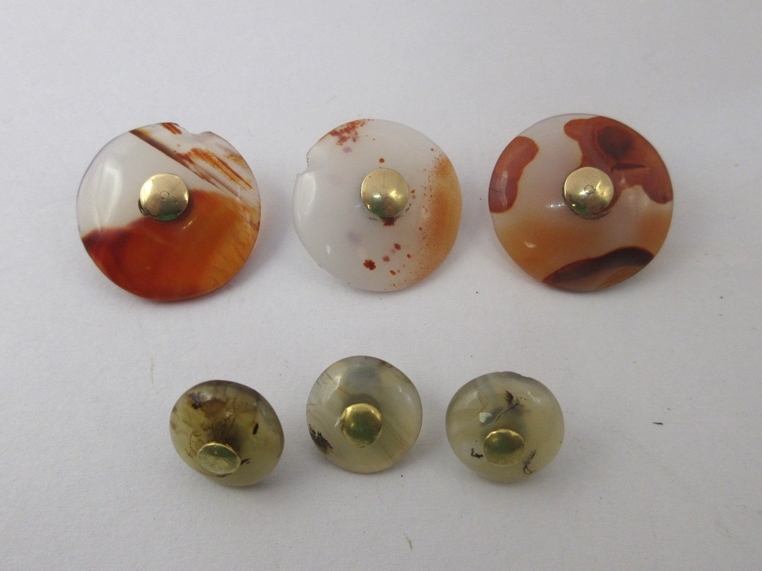 Six agate or similar buttons, each with yellow metal eyelets which acid ...