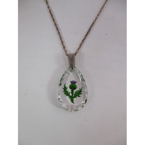 A sterling silver chain with glass pendant featuring a painted thistle ...