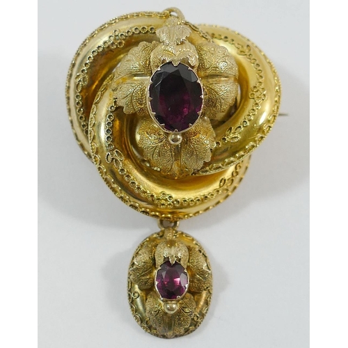 204 - A Victorian gold and garnet set pendant brooch, the hollow brooch of stylised knot form overlaid wit... 