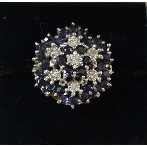 207 - A 9 carat gold large diamond and sapphire cluster ring, the seven eight-cut diamonds in illusion set... 