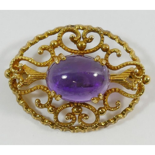 211 - A 9 carat gold oval openwork brooch set with a single cobochon amethyst, 3.6cm x 2.8cm, 10.5g gross