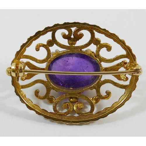 211 - A 9 carat gold oval openwork brooch set with a single cobochon amethyst, 3.6cm x 2.8cm, 10.5g gross