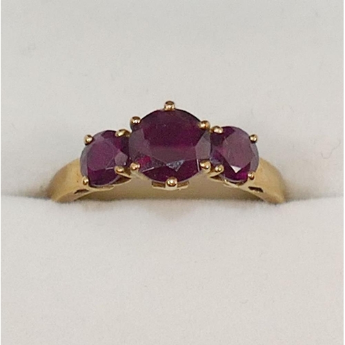 231 - A 9 carat gold almandine garnet three stone ring, the round mixed cut garnets in claw settings, the ... 