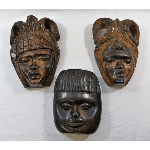 54 - A collection of nine African carvings and sculptures including a pair of masks and a wooden club, 50... 