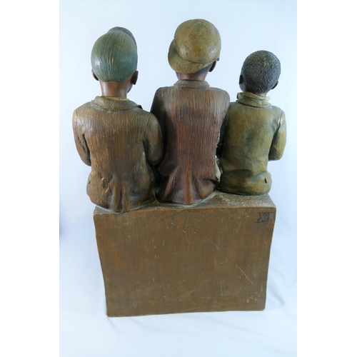 10 - A large Goldscheider pottery model of three boys sitting on a brick wall by B Haniroff, factory stam... 