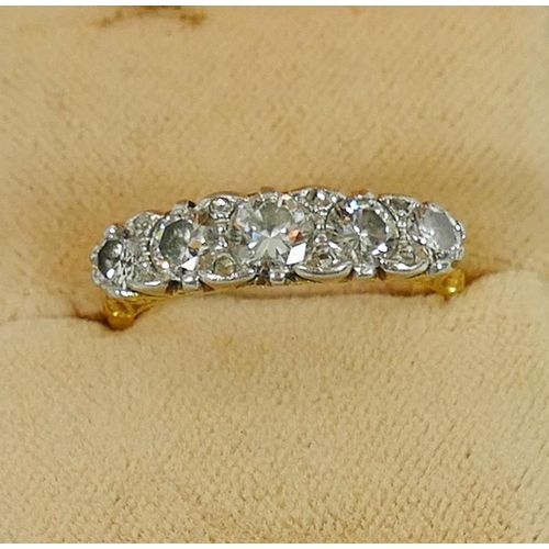 141 - A yellow metal diamond five stone carved half hoop ring, the round brilliant cut diamonds approximat... 