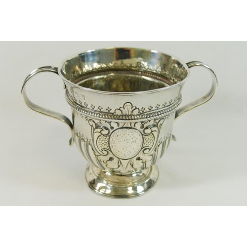 175 - A George I silver porringer, with reeded scroll handles and half reeded and fluted body,  the repous... 