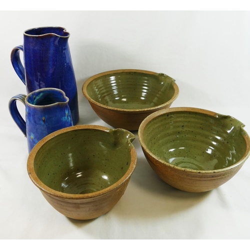 25 - Five items of Studio pottery, comprised of two blue glazed stoneware jugs, 24.5cm high and 14.5cm hi... 