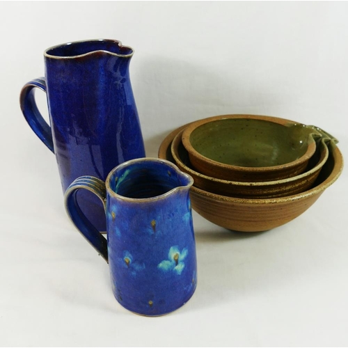 25 - Five items of Studio pottery, comprised of two blue glazed stoneware jugs, 24.5cm high and 14.5cm hi... 