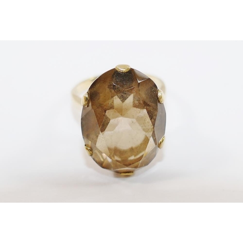 180 - A 9 carat gold smokey quartz single stone ring, the oval mixed cut stone in claw setting, London 197... 