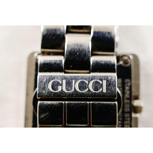 216 - A ladies Gucci stainless steel bracelet watch, the square plain black face within stylised 'G' surro... 