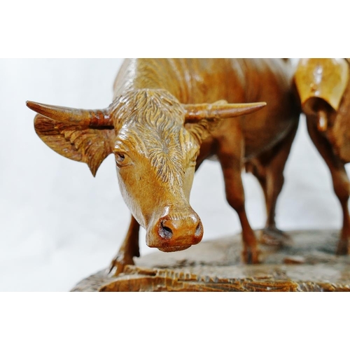 309 - A Swiss Brienz carving of two horned cows, one with a bell, by the  Huggler brothers and stamped 'Hu... 