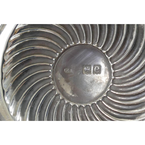 49 - A late Victorian silver circular ink well, with half reeded body and hinged lid, on plain spreading ... 