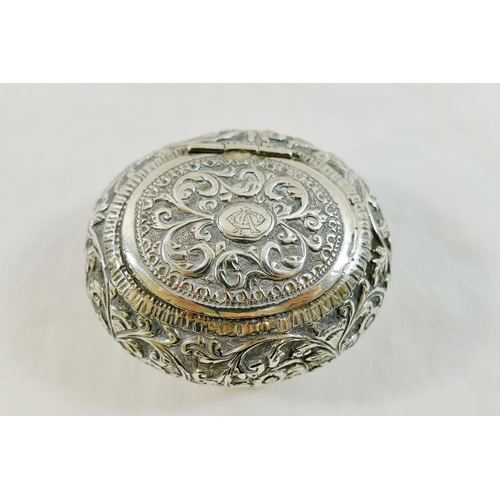 51 - An Indian silver coloured metal oval snuff box, with embossed decoration and hinged lid, 3.5cm x 6cm... 