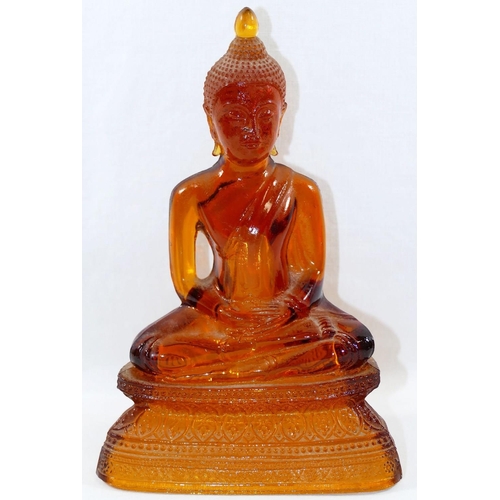 14 - An amber glass seated Buddha, the hollow moulded glass figure depicted in the lotus position with ha... 